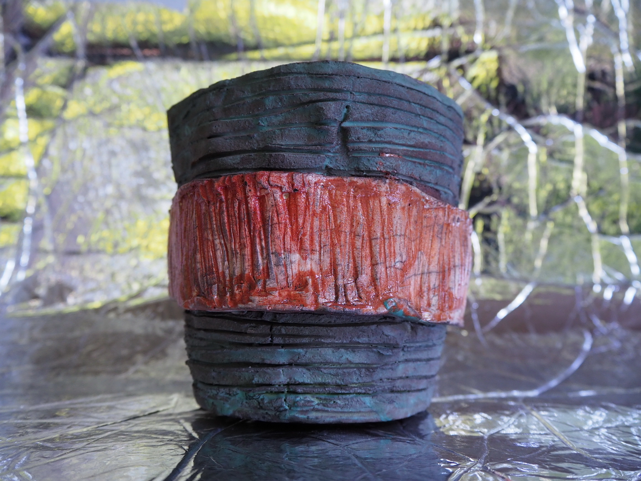 Vaso sperimentale in tecnica raku con superfici incise e fascia centrale in ossido rosso-ambra, esempio di ricerca artistica sulla materia.