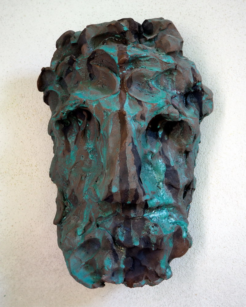 Scultura raku realizzata in kurinuki, un volto materico segnato da crepe, ossidazioni e superfici scavate.